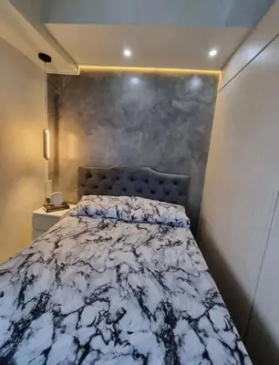 a bedroom with a bed with a white comforter at Cozy Room At Sea Residences in Manila