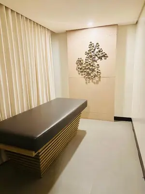 a black bench in a room with a chandelier at We Vibe, 81 Newport Blvd across NAIA 3 in Manila