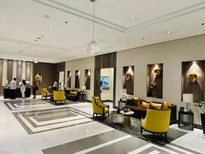 a lobby with yellow chairs and couches in a building at We Vibe, 81 Newport Blvd across NAIA 3 in Manila