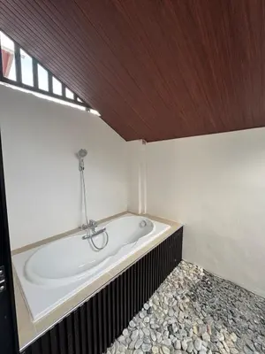 a bath tub in a room with a wooden ceiling at Casa Mira in Dasmariñas
