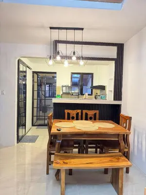 a dining room with a wooden table and chairs at Casa Mira in Dasmariñas