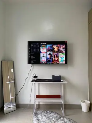 a monitor on a wall with a keyboard on a table at Apartment in Pasay in Manila