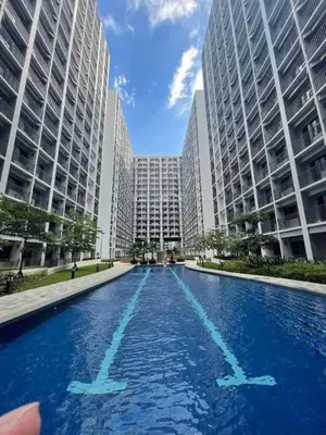a swimming pool in a city with tall buildings at Apartment in Pasay in Manila