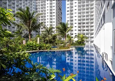 a swimming pool in the middle of a city with tall buildings at Manila Shore Residences Tower D MOA in Manila