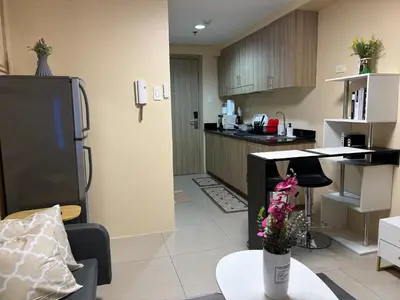 a kitchen and living room with a table and a refrigerator at Manila Shore Residences Tower D MOA in Manila