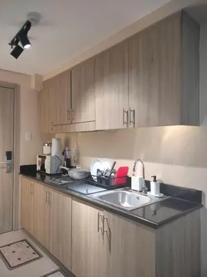a kitchen with wooden cabinets and a sink at Manila Shore Residences Tower D MOA in Manila