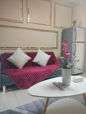 a living room with a purple couch and a table at Manila Shore Residences Tower D MOA in Manila