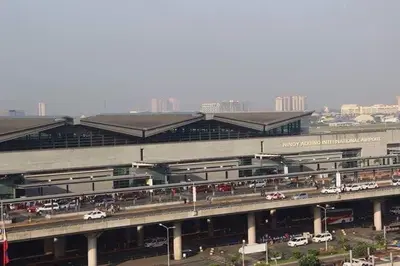 a large building with cars parked in front of it at Cozy Home Right Across International Airport Terminal 3 in Manila
