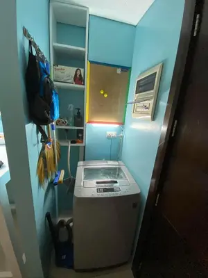 a small blue room with a washing machine in it at Cozy Home Right Across International Airport Terminal 3 in Manila
