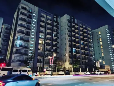 a car driving past a large building at night at Cozy Home Right Across International Airport Terminal 3 in Manila
