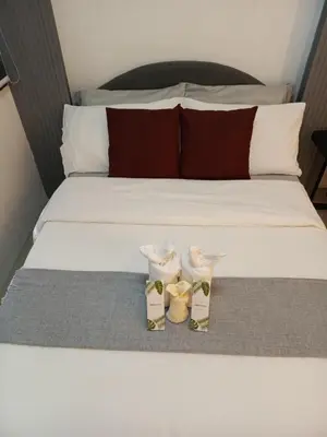 a bed with two pairs of shoes sitting on it at Jasmine Haven in Shore2 Residences in Manila
