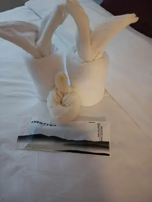 a magazine sitting on a bed with two swans at Jasmine Haven in Shore2 Residences in Manila