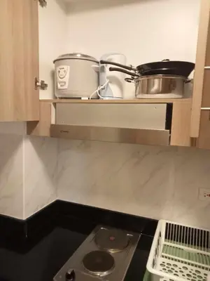 a kitchen with a shelf with pots and pans on it at Jasmine Haven in Shore2 Residences in Manila