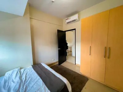 a bedroom with a bed and a closet and a door at Exquisite 2BR Corner Suite with Sunset, Okada View in Manila