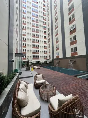 a patio with wicker chairs and tables on a building at Ananda Square in Manila