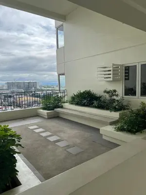 a balcony of a white building with plants at Ananda Square in Manila