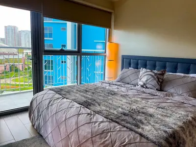 a bedroom with a bed and a large window at Bayshore Resort Residences - Okada Manila in Manila