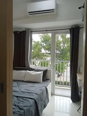 a bedroom with a bed and a large window at Condo sa south residences tower 3 in Manila