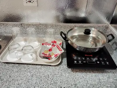 a stove with a pot and some dishes on it at Condo sa south residences tower 3 in Manila
