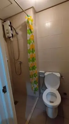 a bathroom with a toilet and a shower curtain at Yuanhang 910 in Manila