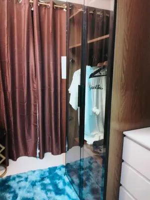 a shower with a glass door in a bathroom at HyrCondotel in Manila