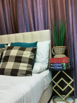 a bed with pillows and a potted plant on it at HyrCondotel in Manila