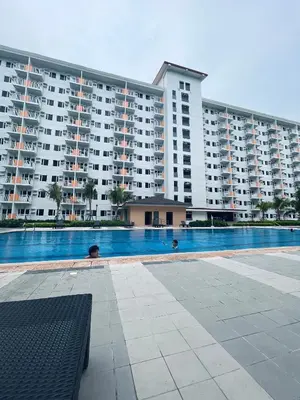 a large apartment building with a large swimming pool at King Elite Condo Hotel Field Residences Near NAIA Airport in Manila