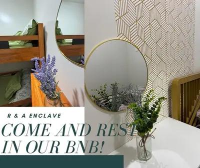 a mirror and a vase with flowers on a table at R & A Enclave in Manila