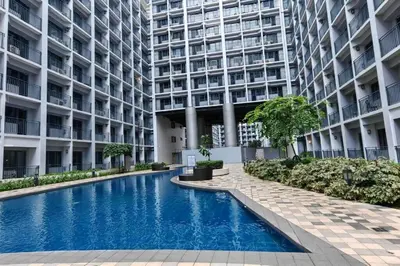 a swimming pool in front of a large building at Cozy Home near Mall of Asia with WIFI and Netflix in Manila