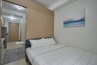 a bedroom with a bed and a table in it at Cozy Home near Mall of Asia with WIFI and Netflix in Manila