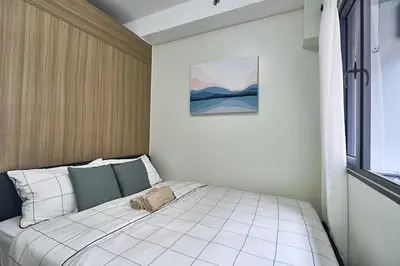 a bed in a bedroom with a picture on the wall at Cozy Home near Mall of Asia with WIFI and Netflix in Manila