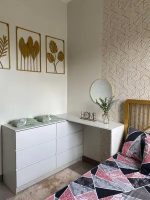 a bedroom with a bed and a dresser with a mirror at R and A Enclave in Manila