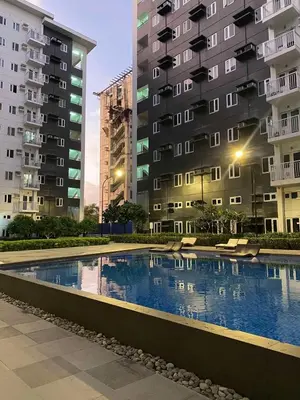 a swimming pool in front of two tall buildings at R and A Enclave in Manila