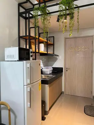 a kitchen with a refrigerator and a door with plants at R and A Enclave in Manila