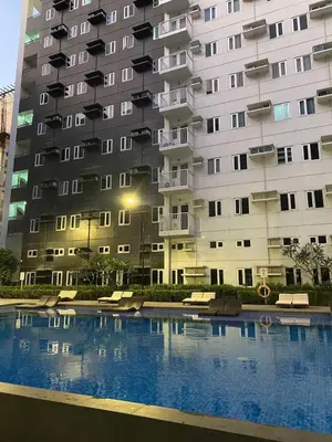 a large building with a swimming pool in front of it at R and A Enclave in Manila