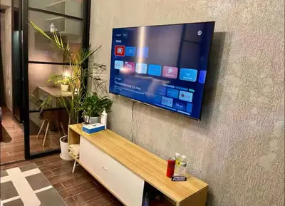 a flat screen tv hanging on a wall at Luxurious 500MBPS 1BR in Makati in Manila