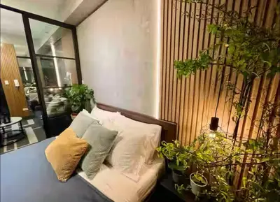 a room with a couch with pillows and potted plants at Luxurious 500MBPS 1BR in Makati in Manila