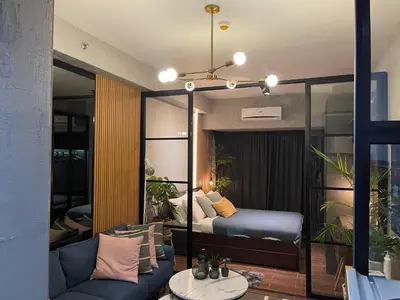 a bedroom with a bed and a couch in a room at Luxurious 500MBPS 1BR in Makati in Manila
