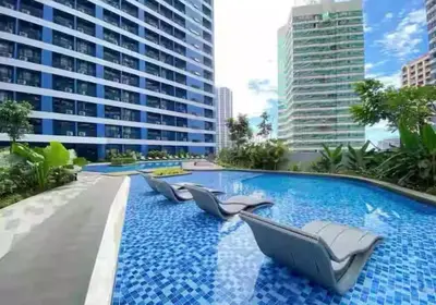 a swimming pool with lounge chairs in a building at Luxurious 500MBPS 1BR in Makati in Manila