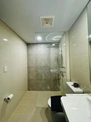 a bathroom with a shower and a toilet and a sink at 7FF Cozy 1BR Park McKinley West near BGC & Venice Mall in Manila