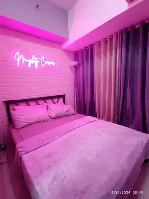 a bedroom with a large bed with pink lighting at Casa Cashmere in Light residences at Mandaluyong City in Manila