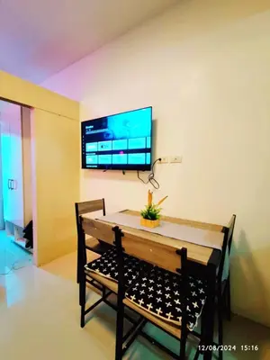 a dining room with a table and a tv on the wall at Casa Cashmere in Light residences at Mandaluyong City in Manila