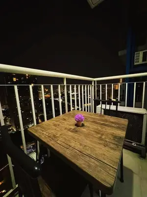 a wooden table on a balcony with a flower pot on it at Casa Cashmere in Light residences at Mandaluyong City in Manila