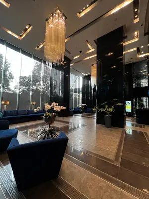 a lobby with couches and a chandelier at Studio unit at The Milano Residences in Manila