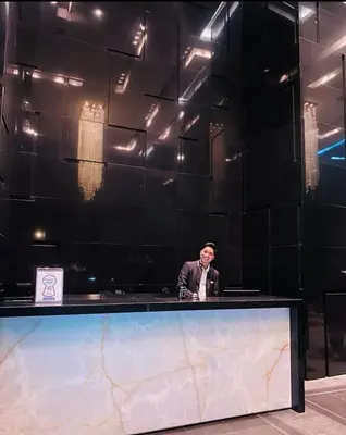 a man standing behind a counter in a black wall at Studio unit at The Milano Residences in Manila