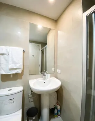 a bathroom with a sink and a toilet and a mirror at Studio unit at The Milano Residences in Manila