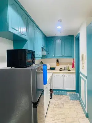 a kitchen with blue cabinets and a refrigerator at Baywtach 1503 in Manila