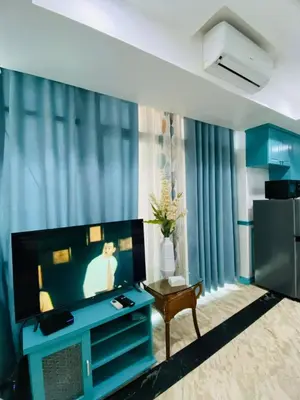 a living room with a tv and a blue wall at Baywtach 1503 in Manila