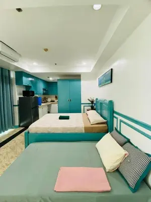 a large room with two beds and a kitchen at Baywtach 1503 in Manila