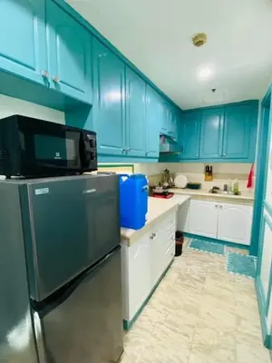 a kitchen with blue cabinets and a refrigerator at Baywtach 1503 in Manila